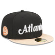 Atlanta Hawks black and peach script 59FIFTY fitted hat featuring embroidered team name and logo.