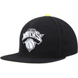 New York Knicks black and yellow snapback hat featuring a bold team logo and basketball design on the front.