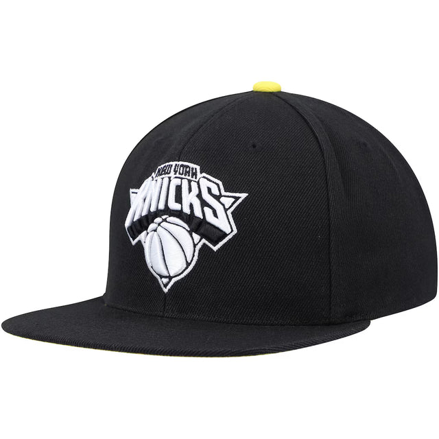 New York Knicks black and yellow snapback hat featuring a bold team logo and basketball design on the front.